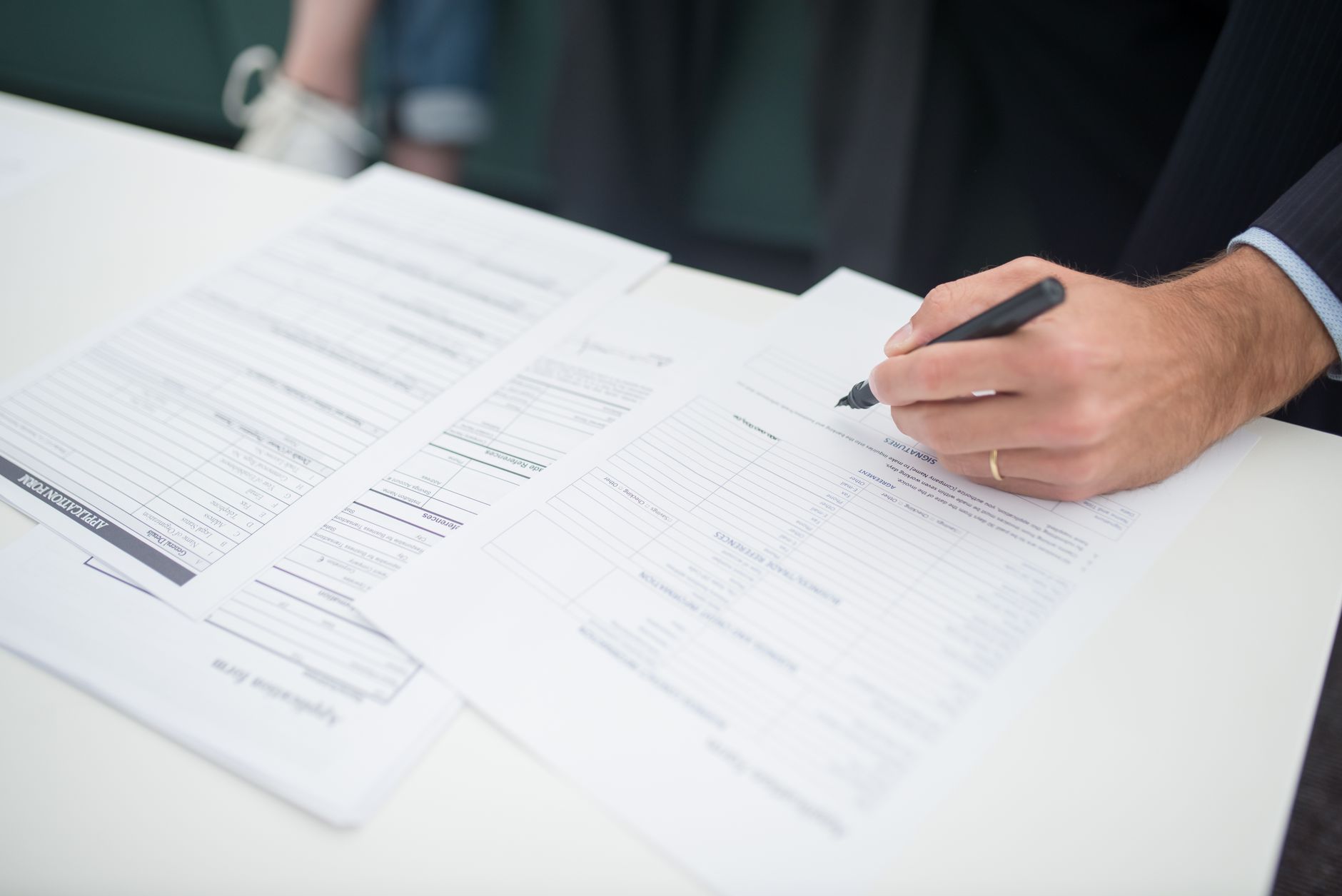 Contract paperwork on a desk — the tools most owners still rely on for a business sale